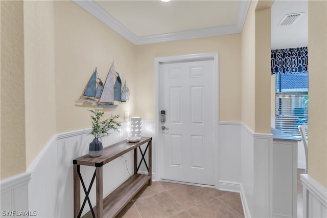 foyer entrance with light tile patterned floors and crown molding