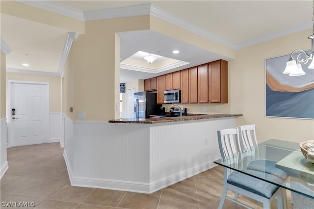 kitchen featuring appliances with stainless steel finishes, light tile patterned flooring, kitchen peninsula, and crown molding