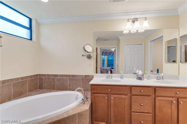 bathroom with tiled tub, double sink vanity, and crown molding