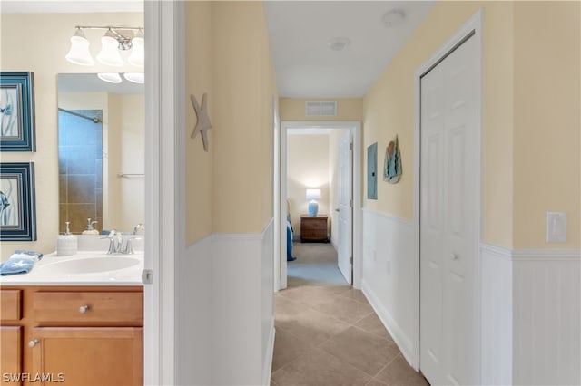 hallway featuring sink and light tile patterned floors