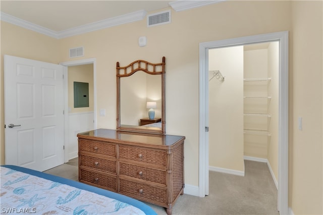 carpeted bedroom featuring ornamental molding, a closet, electric panel, and a walk in closet