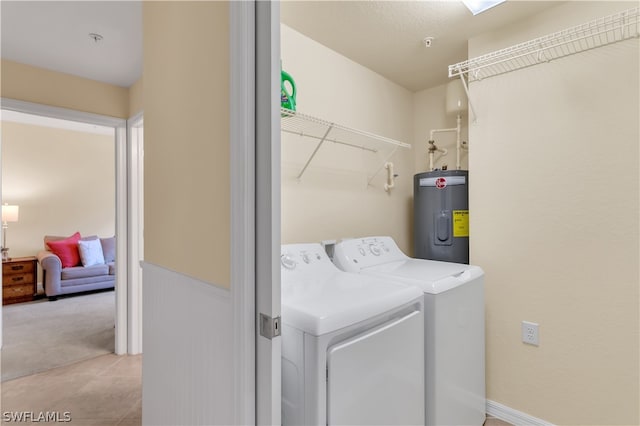 clothes washing area featuring washing machine and clothes dryer, light carpet, and water heater