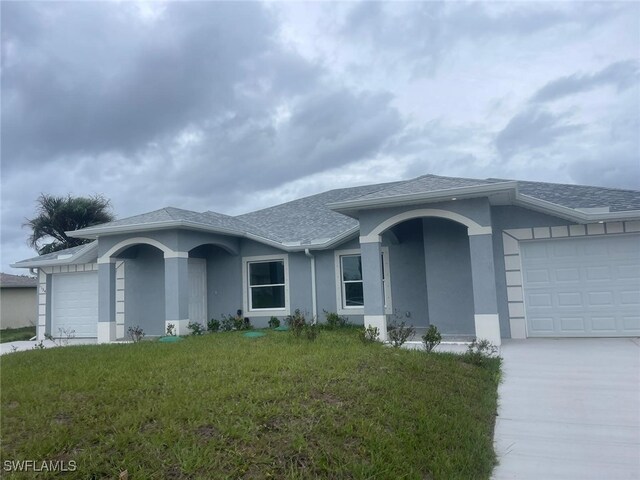1132/1134 Harold Ave S, Lehigh Acres, FL 33973 - ranch-style home featuring a garage, stucco siding, concrete driveway, a front yard, and a shingled roof