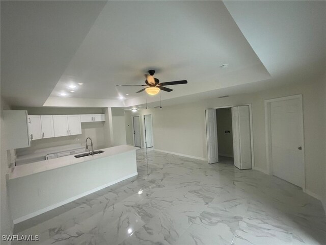 1132/1134 Harold Ave S, Lehigh Acres, FL 33973 - kitchen featuring a sink, baseboards, white cabinetry, a peninsula, and a tray ceiling