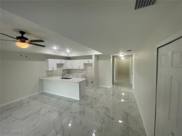 1132/1134 Harold Ave S, Lehigh Acres, FL 33973 - kitchen with a peninsula, baseboards, a sink, white cabinets, and light countertops
