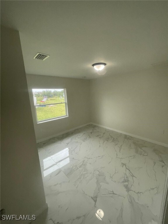 1132/1134 Harold Ave S, Lehigh Acres, FL 33973 - unfurnished room with baseboards and marble look tiles