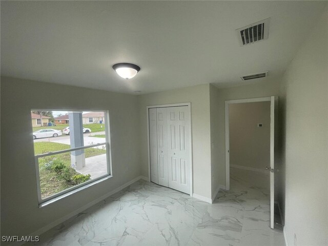 1132/1134 Harold Ave S, Lehigh Acres, FL 33973 - unfurnished bedroom with baseboards, marble finish floors, and a closet