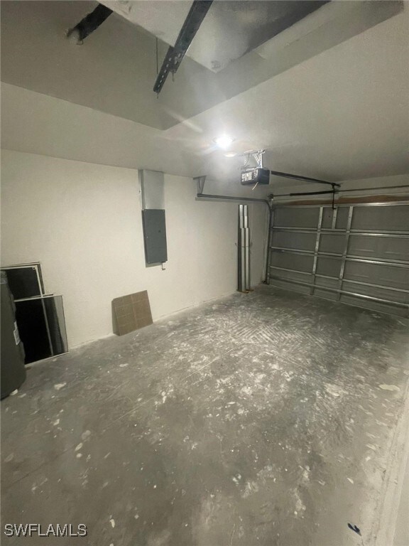 1132/1134 Harold Ave S, Lehigh Acres, FL 33973 - garage featuring electric panel and a garage door opener