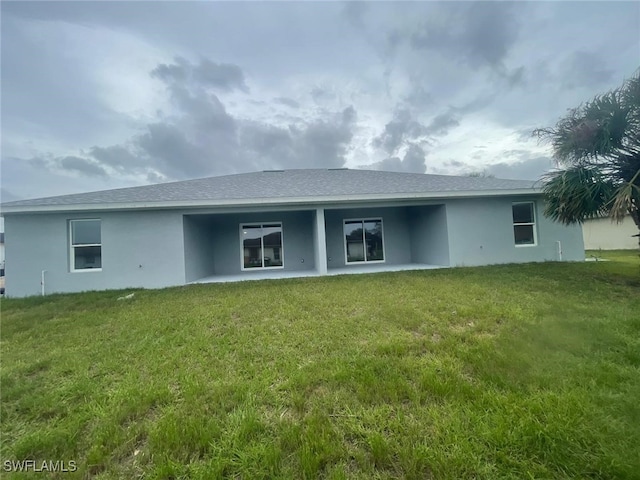 1132/1134 Harold Ave S, Lehigh Acres, FL 33973 - rear view of house with stucco siding, a lawn, and a patio area