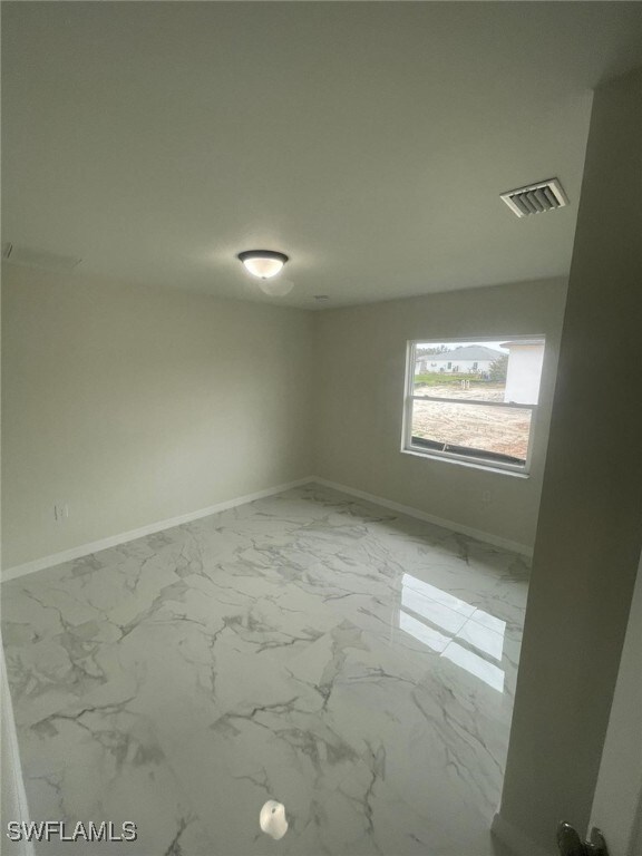 1132/1134 Harold Ave S, Lehigh Acres, FL 33973 - unfurnished room featuring baseboards and marble look tiles
