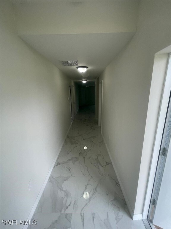 1132/1134 Harold Ave S, Lehigh Acres, FL 33973 - hallway with baseboards and light marble finish floors