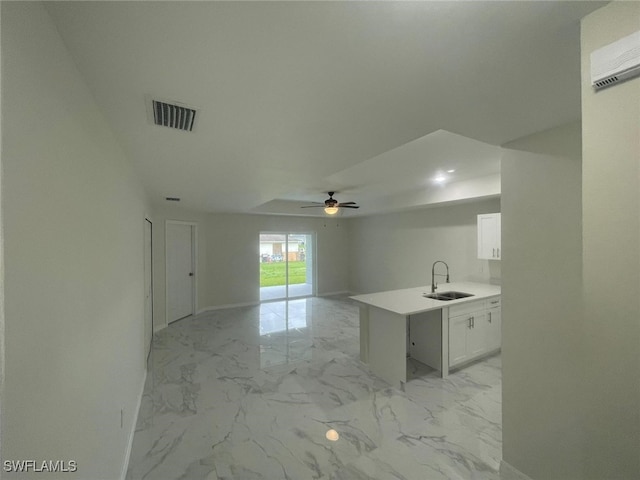 1132/1134 Harold Ave S, Lehigh Acres, FL 33973 - kitchen with a sink, a wall unit AC, ceiling fan, white cabinetry, and light marble finish floors