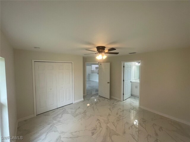 1132/1134 Harold Ave S, Lehigh Acres, FL 33973 - unfurnished bedroom featuring light marble finish flooring, baseboards, a closet, a ceiling fan, and ensuite bathroom
