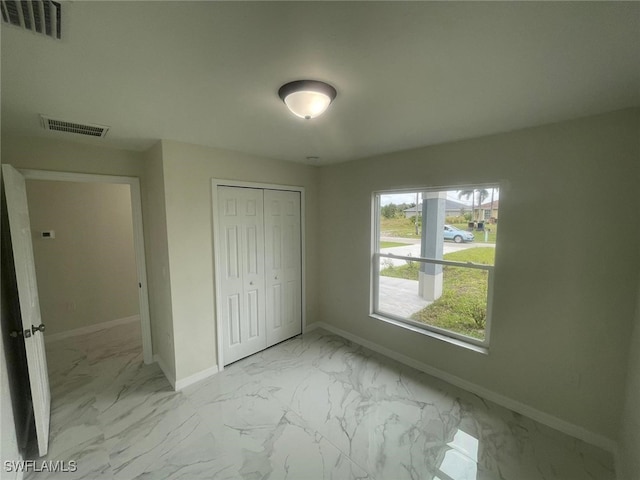 1132/1134 Harold Ave S, Lehigh Acres, FL 33973 - unfurnished bedroom with marble look tile flooring, baseboards, and a closet