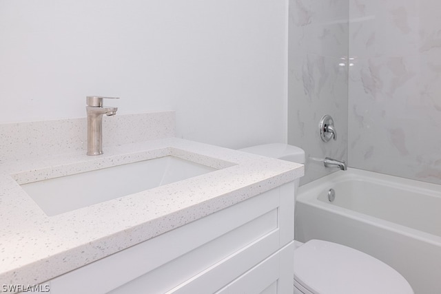 full bathroom with vanity, tiled shower / bath combo, and toilet