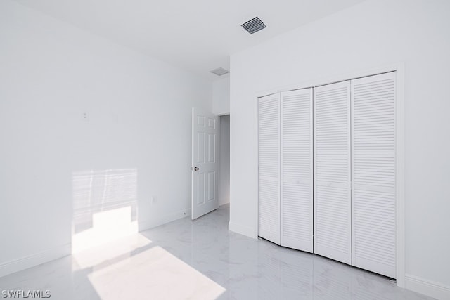 unfurnished bedroom featuring a closet and light tile patterned floors