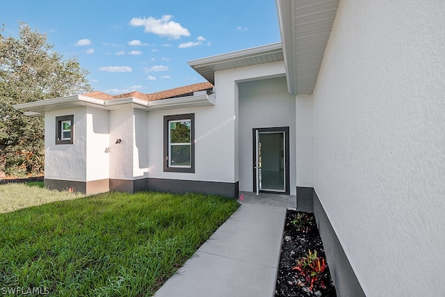 entrance to property featuring a lawn