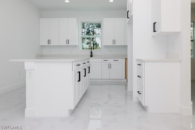 kitchen featuring light tile patterned flooring, a kitchen island, and white cabinets