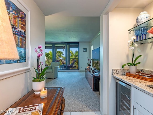 carpeted living room featuring wine cooler and bar area