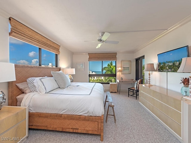 carpeted bedroom with ornamental molding and ceiling fan