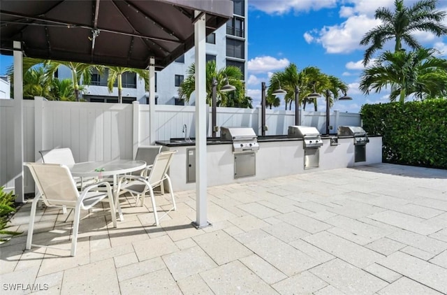 view of patio / terrace with an outdoor kitchen, grilling area, and sink