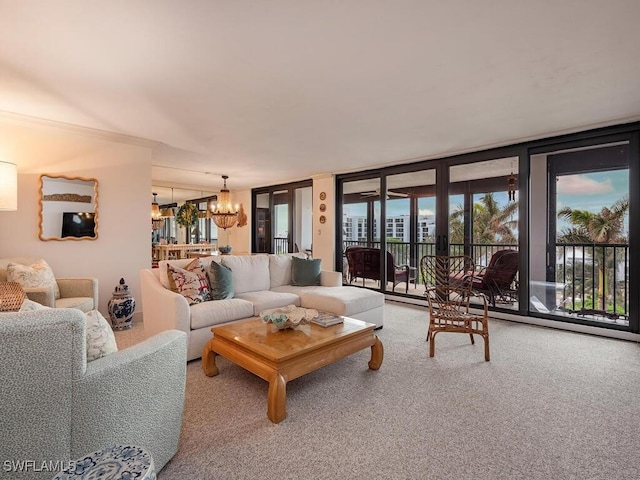 living room featuring carpet flooring, a chandelier, and a wall of windows