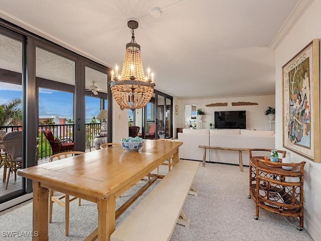 carpeted dining space featuring ornamental molding, french doors, and a chandelier