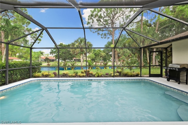 view of swimming pool with grilling area and glass enclosure