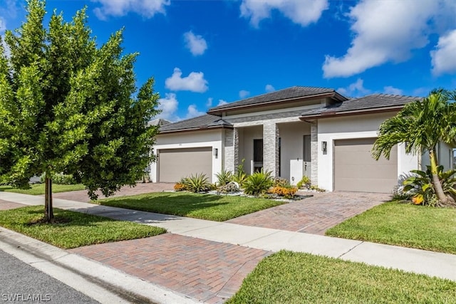 prairie-style house with a garage and a front lawn