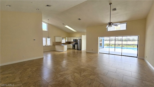 unfurnished living room featuring light tile patterned floors, high vaulted ceiling, and ceiling fan