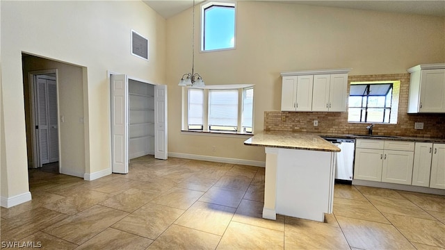 kitchen featuring white cabinets, backsplash, light tile patterned floors, high vaulted ceiling, and dishwasher