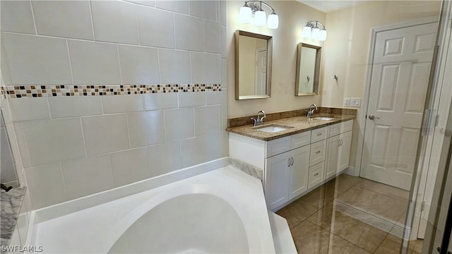 bathroom featuring dual vanity, a tub to relax in, and tile patterned flooring