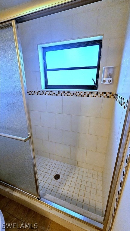 bathroom featuring a shower with shower door and tile patterned floors