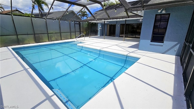 view of pool featuring glass enclosure and a patio area