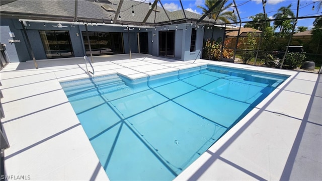 view of pool with a patio area and a lanai