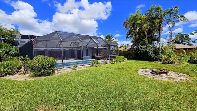 view of yard featuring an outdoor fire pit and glass enclosure