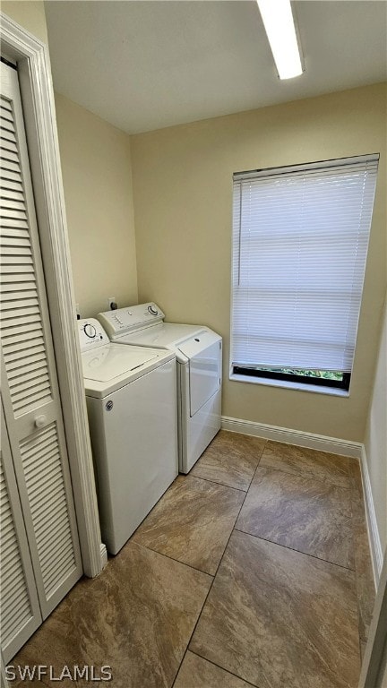 washroom with washing machine and clothes dryer and light tile patterned floors