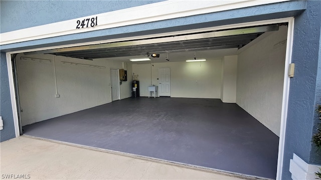 garage with a garage door opener, water heater, and electric panel