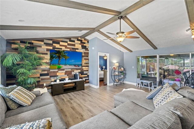 living room featuring wood walls, vaulted ceiling with beams, light wood-type flooring, and ceiling fan