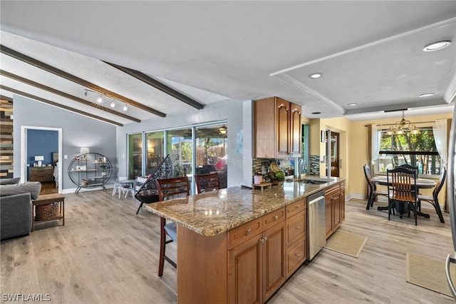 kitchen featuring a notable chandelier, stone counters, sink, lofted ceiling with beams, and light hardwood / wood-style floors