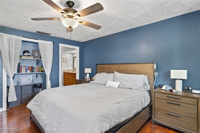 bedroom with dark hardwood / wood-style flooring, a textured ceiling, ceiling fan, and connected bathroom