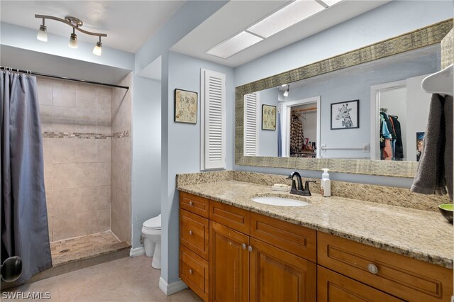 bathroom featuring tile patterned flooring, curtained shower, toilet, and vanity