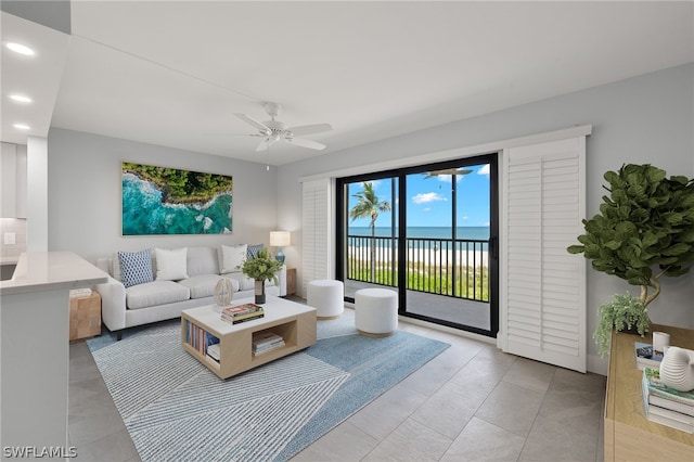 living room with a water view and ceiling fan