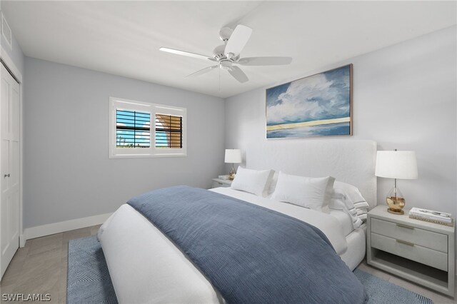 bedroom featuring a closet, light tile patterned floors, and ceiling fan