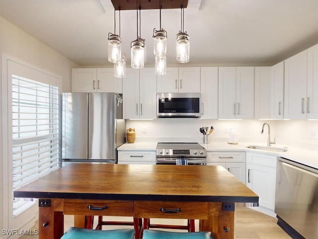 kitchen featuring sink, white cabinets, light wood-type flooring, and stainless steel appliances