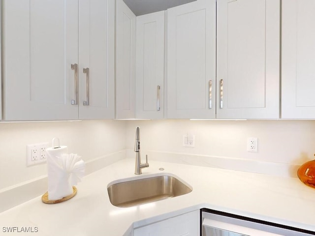 kitchen with sink, dishwasher, and white cabinets