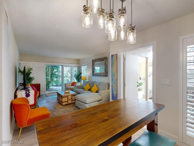 dining area with wood-type flooring and an inviting chandelier