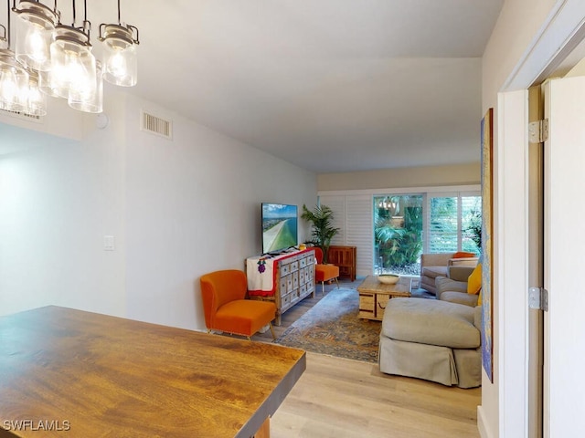 living room with hardwood / wood-style flooring and a notable chandelier