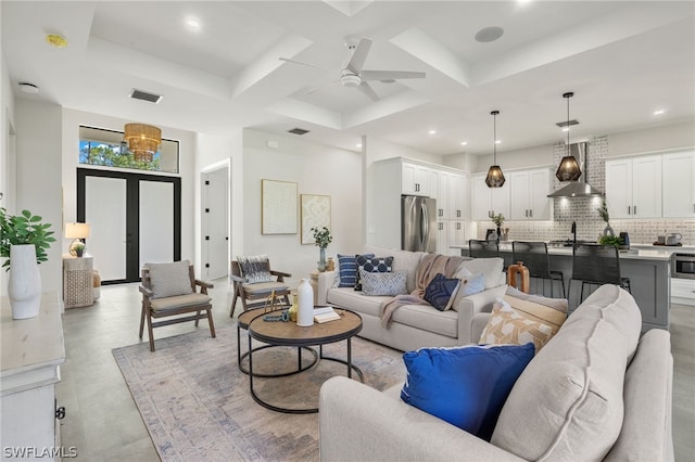 tiled living room with coffered ceiling, ceiling fan, and french doors