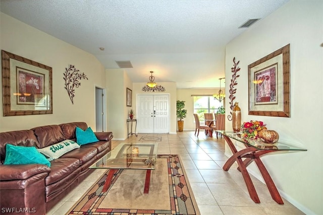 living room with a textured ceiling and light tile patterned floors